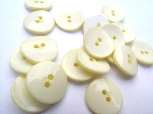 Gombík dvojdierkový hrubší ohnutý lesklý 20mm/maslový