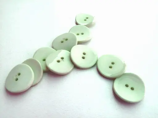 Gombík dvojdierkový hrubší ohnutý lesklý 18mm/mentolový